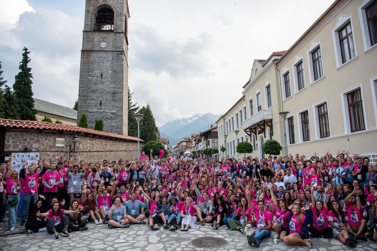 A group of 400 people in Bansko town square wearing pink tshirts cheering